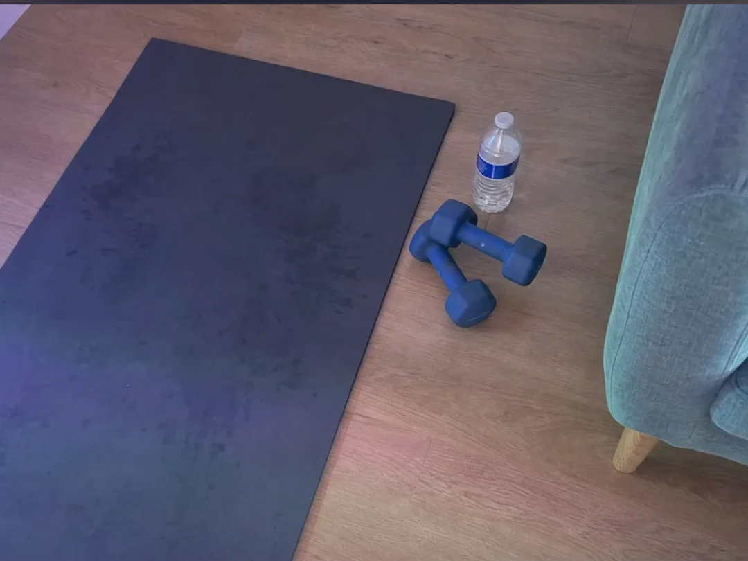 Un tapis de sol et des haltères posés dans un salon